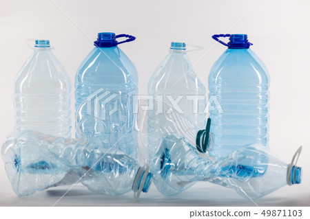 Opened clear big plastic jars standing behind and a few crumpled 49871103