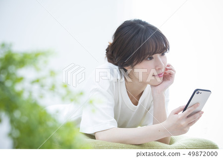 A young woman watching a smartphone A young woman watching a smartphone 49872000