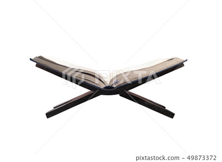 Quran open on wooden placemat Quran open on wooden placemat 49873372