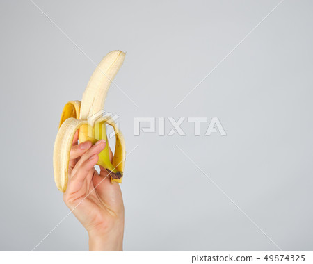 peeled fresh banana in female hand peeled fresh banana in female hand 49874325
