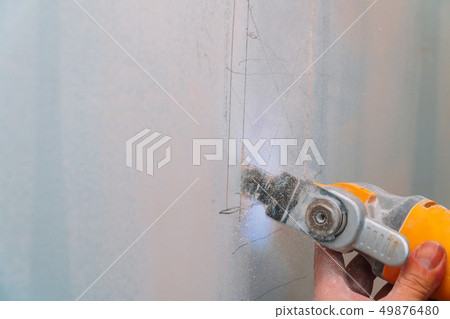 Construction worker cutting gypsum plasterboard 49876480