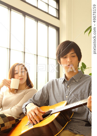 Image of a boyfriend and her girlfriend playing the guitar Image of a boyfriend and her girlfriend playing the guitar 49878159