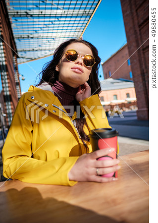 young woman in yellow raincoat at city street young woman in yellow raincoat at city street 49880455
