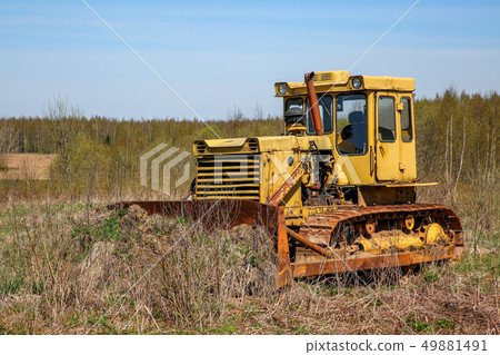 Old crawler tractor in the field. 49881491