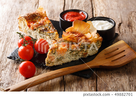 Fish pie with tomatoes, cheese and herbs close-up. 49882701
