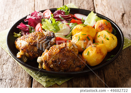 Portion of chicken thighs with new potatoes and 49882722