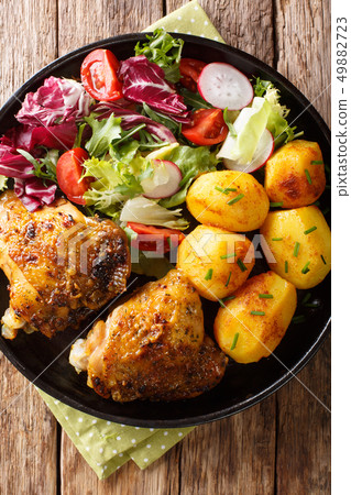 Baked chicken thighs with a garnish of new 49882723