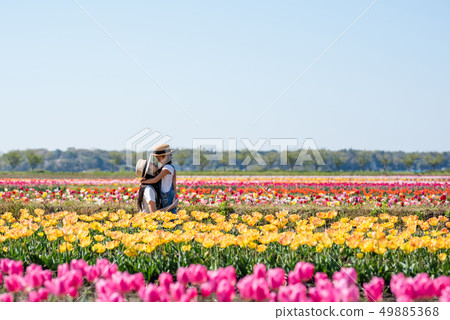 Mother and daughter playing in the flower field Mother and daughter playing in the flower field 49885368