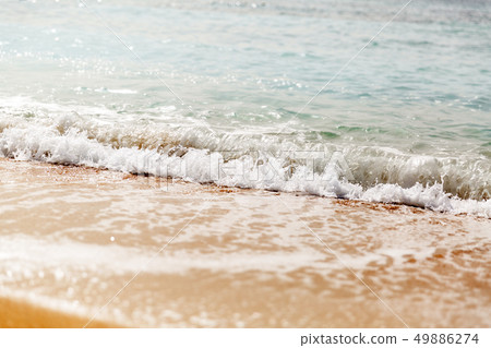 Powerful blue wave breaks along the shore. Close 49886274