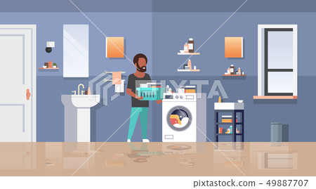 man with clothes basket standing near washing machine african american guy doing housework laundry man with clothes basket standing near washing machine african american guy doing housework laundry 49887707