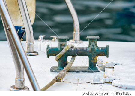 Close up of boat rope tied to nautical cleat hitch on boat Close up of boat rope tied to nautical cleat hitch on boat 49888193