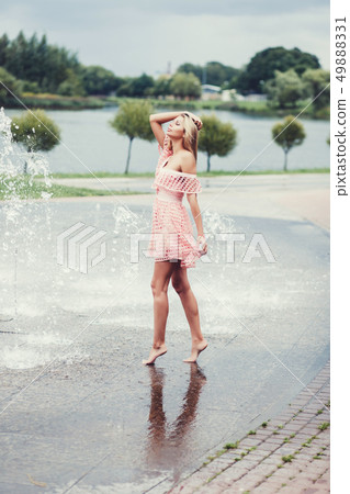 woman model posing in dress near fountain 49888331