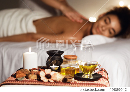 African woman enjoying aromatherapy massage in luxury spa African woman enjoying aromatherapy massage in luxury spa 49889042