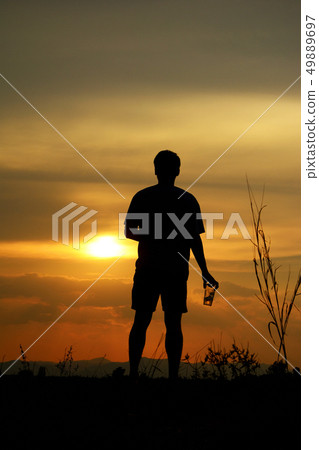 silhouette of a lonely man holding a beer glass silhouette of a lonely man holding a beer glass 49889697