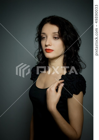 Amazing young girl with red sensual lips and dark hair posing on black background in studio Amazing young girl with red sensual lips and dark hair posing on black background in studio 49890033