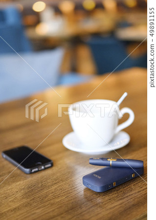 Moscow, Russia, IQOS heat-not-burn tobacco product technology. Man holding e-cigarette in his hand Moscow, Russia, IQOS heat-not-burn tobacco product technology. Man holding e-cigarette in his hand 49891155