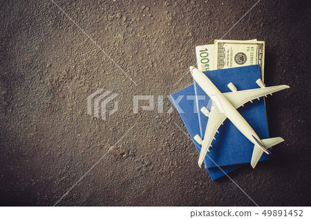 Miniature airplane, two passports and money on a Miniature airplane, two passports and money on a 49891452