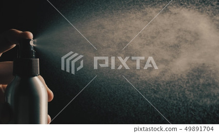 Sprinkling water or perfume against dark background Sprinkling water or perfume against dark background 49891704