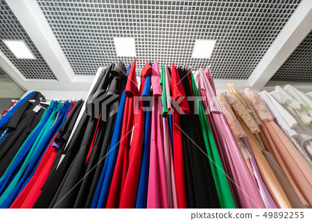 Cocktail dress. Clothing on hanger at the modern shop boutique. Bright multi-colored fabrics 49892255