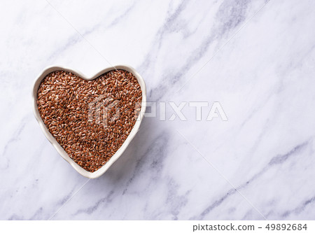 Flax seeds in heart shape bowl Flax seeds in heart shape bowl 49892684
