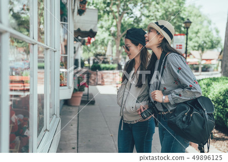 women standing outside store looking window 49896125