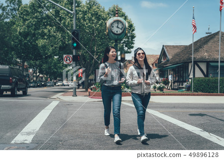 two Asian friends walking down alley together 49896128