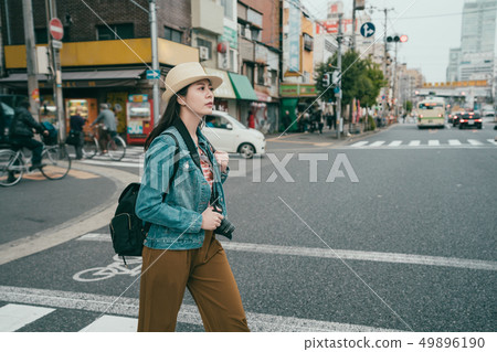 female traveler walking on pedestrian crossing 49896190