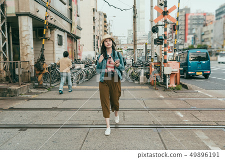 female carrying camera while crossing railway female carrying camera while crossing railway 49896191