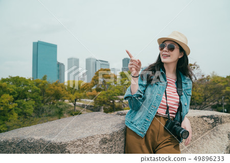 girl pointing to sky with background skyscraper girl pointing to sky with background skyscraper 49896233