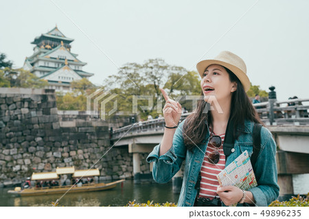 happy tourist asian girl holding paper map happy tourist asian girl holding paper map 49896235