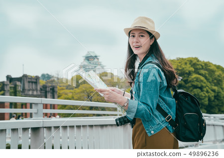 young female backpacker holding paper map young female backpacker holding paper map 49896236
