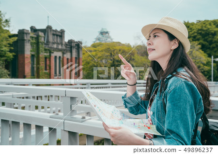 woman with map pointing to beautiful top view woman with map pointing to beautiful top view 49896237