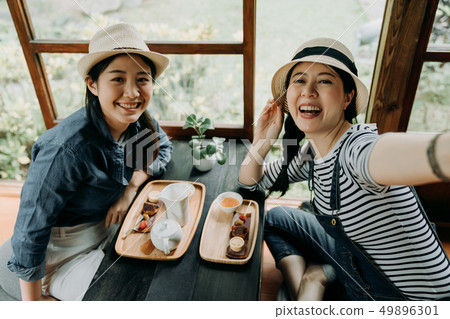 women taking selfie in wooden traditional house 49896301