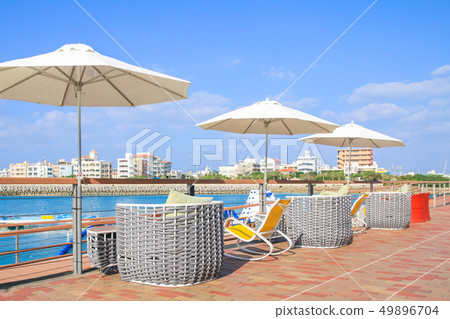 Beachside outdoor cafe (blue sky and parasol) Beachside outdoor cafe (blue sky and parasol) 49896704