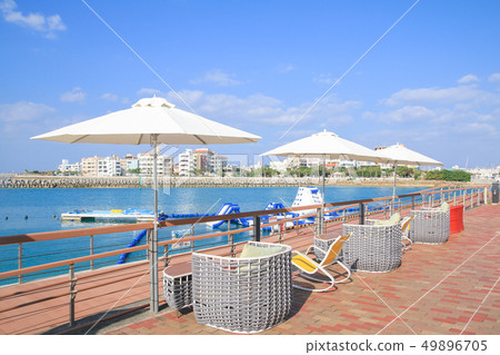 Beachside outdoor cafe (blue sky and parasol) 49896705