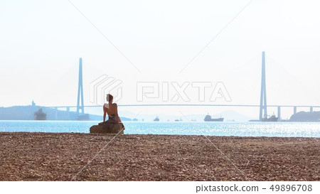 The girl sunbathes in the morning sun on the The girl sunbathes in the morning sun on the 49896708