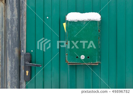The mailbox is green next to the wicket house. The mailbox is green next to the wicket house. 49896782