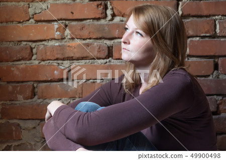 Side view of a saddly young woman Side view of a saddly young woman 49900498