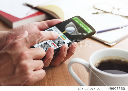 Close-up of male hands doing online shopping of golf with a smartphone. 49902360