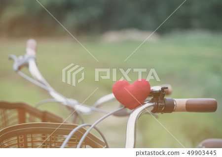 A little red heart pillow on the bicycle 49903445