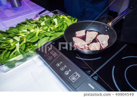 Raw Tuna Steaks served on metal frying pan, chili oil, salt 49904549