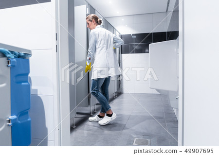 Cleaning lady or janitor mopping the floor in restroom 49907695