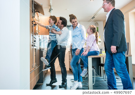 Family looking at a new kitchen in the showroom  49907697