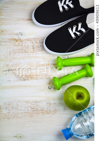Gym shoes, dumbbells, a bottle of water, an apple Gym shoes, dumbbells, a bottle of water, an apple 49909813