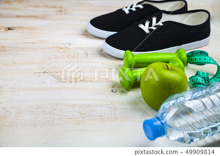 Gym shoes, dumbbells, a bottle of water, an apple Gym shoes, dumbbells, a bottle of water, an apple 49909814