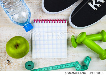 Gym shoes, dumbbells, a bottle of water, an apple Gym shoes, dumbbells, a bottle of water, an apple 49909816