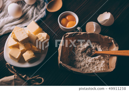 Top view of diced butter, sack of flour, raw yolks 49911238