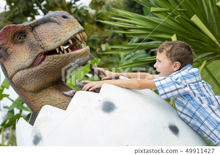 little boy playing in the adventure dino park. 49911427