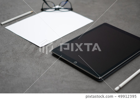 tablet with pen on a concrete table tablet with pen on a concrete table 49912395