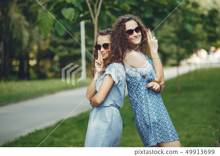 Two cute sisters in a summer park 49913699